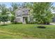 Beautiful two-story home featuring a spacious lawn, mature trees, and stylish landscaping at 1324 Sandybrook Ln, Wake Forest, NC 27587
