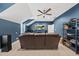 Living room with a brown leather sofa, ceiling fan and a large TV at 1324 Sandybrook Ln, Wake Forest, NC 27587