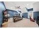 Living room with a leather sofa and a gaming chair next to a window at 1324 Sandybrook Ln, Wake Forest, NC 27587