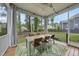 Inviting screened-in porch with a dining table, chairs, and outdoor decor with view of the backyard at 1324 Sandybrook Ln, Wake Forest, NC 27587