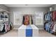 This walk-in closet has built-in shelves, windows, and an island with a blue runner at 1324 Sandybrook Ln, Wake Forest, NC 27587