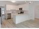 Modern kitchen featuring stainless steel appliances, white cabinets, an eat-in bar, and an adjacent dining area at 137 Wintermist Dr, Cary, NC 27513