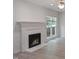 Bright living room featuring a fireplace, wood-look floors, and large windows overlooking the yard at 137 Wintermist Dr, Cary, NC 27513