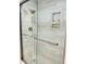 Modern bathroom features a glass-enclosed shower with white marble tiling and built in shelving at 1512 Cumberland Rd, Chapel Hill, NC 27514
