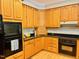 Kitchen features lots of wooden cabinets, granite countertops and black appliances at 1512 Cumberland Rd, Chapel Hill, NC 27514