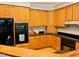 Kitchen features lots of wooden cabinets, granite countertops and black appliances at 1512 Cumberland Rd, Chapel Hill, NC 27514