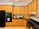Kitchen features lots of wooden cabinets, granite countertops and black appliances at 1512 Cumberland Rd, Chapel Hill, NC 27514
