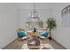 Bright dining room with a modern chandelier, wicker chairs and a glass-top table with seating for four at 1536 Maybrook Dr, Raleigh, NC 27610