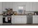 Modern kitchen featuring stainless steel appliances, white cabinetry, and a window over the sink at 1536 Maybrook Dr, Raleigh, NC 27610