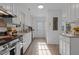 Bright kitchen features white cabinets, stainless steel appliances and light colored floor at 1536 Maybrook Dr, Raleigh, NC 27610