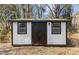 Well-maintained shed with black trim and double doors, providing ample storage space at 1536 Maybrook Dr, Raleigh, NC 27610
