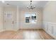 Bright dining room featuring hardwood floors, wainscoting, and a modern chandelier at 162 Gumtop Dr, Zebulon, NC 27597