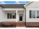 Inviting front porch of home with brick accents and white pillars at 162 Gumtop Dr, Zebulon, NC 27597