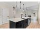 The kitchen island features a sink, dishwasher, and dark cabinets, with stainless steel appliances at 162 Gumtop Dr, Zebulon, NC 27597