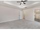 The spacious main bedroom offers a neutral color palette, tray ceilings, plush carpet, and two windows at 162 Gumtop Dr, Zebulon, NC 27597