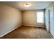 Bedroom features carpet flooring, neutral walls, with a single window and door at 1746 Hammocks Beach Trl, Apex, NC 27502