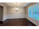 Bright dining room with hardwood floors, wainscoting, and elegant chandelier lighting at 1746 Hammocks Beach Trl, Apex, NC 27502