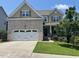 Charming two-story home with a brick front, manicured lawn, and a two-car garage at 1746 Hammocks Beach Trl, Apex, NC 27502