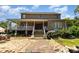 Spacious backyard featuring a brick patio and elevated porch with white railings at 1770 Gentry Ridge Rd, Roxboro, NC 27574