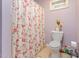 Compact bathroom featuring a floral shower curtain, neutral flooring and a window with bright lighting at 1770 Gentry Ridge Rd, Roxboro, NC 27574