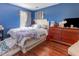 Bright bedroom with hardwood floors, dresser, and a bed with decorative pillows at 1770 Gentry Ridge Rd, Roxboro, NC 27574