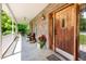Inviting front porch featuring brick, a wooden door, and a cozy seating area at 1770 Gentry Ridge Rd, Roxboro, NC 27574