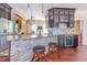 An open kitchen with granite countertops, stone backsplash, dark wood cabinets and stainless steel refrigerator at 1770 Gentry Ridge Rd, Roxboro, NC 27574