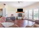 Living room features a stone fireplace, wood floors, and access to the backyard through french doors at 1770 Gentry Ridge Rd, Roxboro, NC 27574