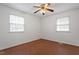 Empty bedroom featuring hardwood floors, white walls, a ceiling fan, and windows at 1813 Grady Dr., Durham, NC 27712