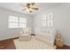 Bedroom room with a white crib, comfortable chair, wood floors and soft decor at 1813 Grady Dr., Durham, NC 27712