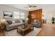 Bright living room featuring hardwood floors, a gray couch, a wood accent wall, and large windows at 1813 Grady Dr., Durham, NC 27712