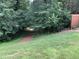 Landscaped backyard features a grassy lawn and tree-lined views of the home's exterior at 186 St. Andrews Ln, Chapel Hill, NC 27517