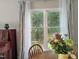 Dining area with view of lush, green foliage and a window with curtains at 186 St. Andrews Ln, Chapel Hill, NC 27517