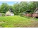 Spacious backyard with a large green lawn, mature trees, and detached garage at 1869 Brevard Rd, Graham, NC 27253