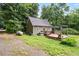 Charming home featuring a deck with pergola, gravel driveway, and wooded surroundings at 1869 Brevard Rd, Graham, NC 27253