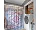 Bathroom featuring a white washer and dryer unit in an open utility space with overhead shelves for storage at 1869 Brevard Rd, Graham, NC 27253