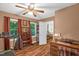 Spare bedroom featuring hardwood floors, curtains, a ceiling fan, and a view into the home's living room at 1869 Brevard Rd, Graham, NC 27253