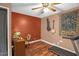 Spare bedroom featuring hardwood floors, curtains, a ceiling fan, and a view into the home's living room at 1869 Brevard Rd, Graham, NC 27253