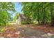 Quaint home nestled among mature trees, with a gravel driveway at 1869 Brevard Rd, Graham, NC 27253