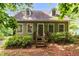 Charming, two-story home featuring dormer windows and a welcoming front porch surrounded by mature landscaping at 1869 Brevard Rd, Graham, NC 27253