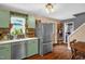 Well-maintained kitchen with painted cabinets, stainless steel refrigerator, and hardwood floors at 1869 Brevard Rd, Graham, NC 27253