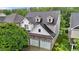 Aerial view showcases a home with a gray roof, a stone garage, and surrounded by green trees at 2067 Glenkirk Dr, Burlington, NC 27215