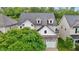 Aerial view of a two-story house with a gray roof and stone-accented garage surrounded by lush greenery at 2067 Glenkirk Dr, Burlington, NC 27215