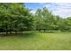 Green backyard with lush lawn and mature trees offering shade and a serene outdoor space at 2067 Glenkirk Dr, Burlington, NC 27215