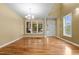 Open dining area with hardwood floors, chandelier lighting, and multiple windows providing natural light at 2067 Glenkirk Dr, Burlington, NC 27215