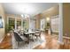 Bright dining room featuring hardwood floors, modern chandelier, large windows, and elegant decor at 2067 Glenkirk Dr, Burlington, NC 27215
