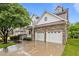 Beautiful home with stone accents, a two-car garage, covered porch, and a manicured lawn under a bright blue sky at 2067 Glenkirk Dr, Burlington, NC 27215