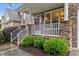 Attractive home showcasing stone accents, a cozy porch with white railings, and manicured landscaping at 2067 Glenkirk Dr, Burlington, NC 27215