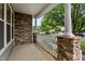 Covered front porch features stone columns and white railings, creating a welcoming entrance to the home at 2067 Glenkirk Dr, Burlington, NC 27215