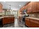 Spacious kitchen with dark wood cabinetry, tile floors, and stainless steel appliances at 2067 Glenkirk Dr, Burlington, NC 27215